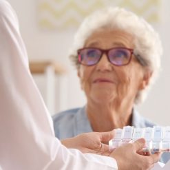 Providing medicine and instruction to senior elderly woman at home
